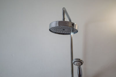 Low angle view of electric lamp against wall