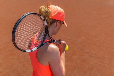 Rear view of tennis player on field