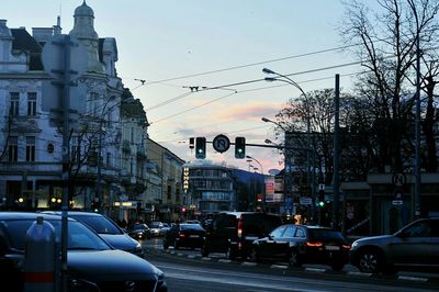 Cars on city street against sky