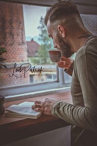 Side view of young man using laptop on table