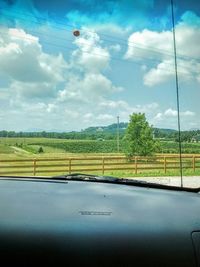 Scenic view of field against cloudy sky