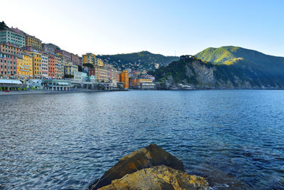 Scenic view of sea by buildings against clear sky