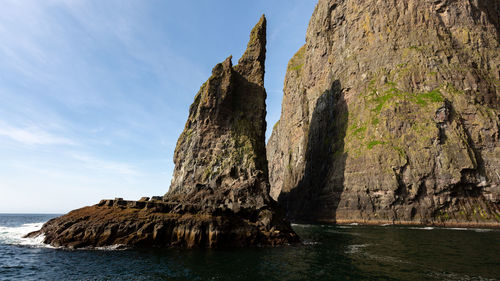 Rock formations by sea against sky