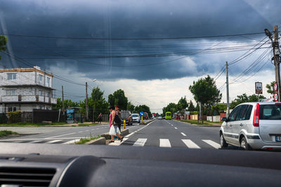 Man on street against sky