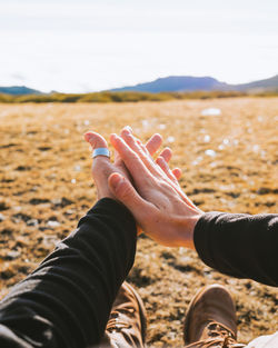 Midsection of woman hand on land against sky