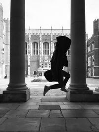 Side view of person jumping next to pillars