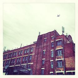 Low angle view of airplane flying against sky