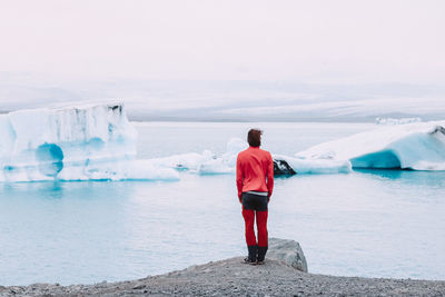 Rear view of man standing by the glaciers