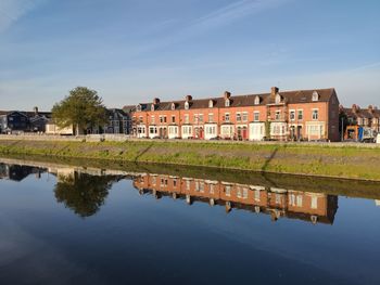 Reflection of buildings on lake against sky