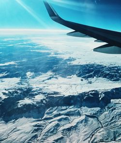 Aerial view of airplane wing over snow landscape