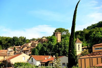 Houses and trees against blue sky