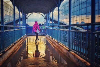 Rear view of woman walking on bridge