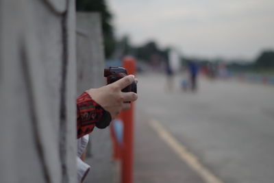 Cropped hands of person holding camera