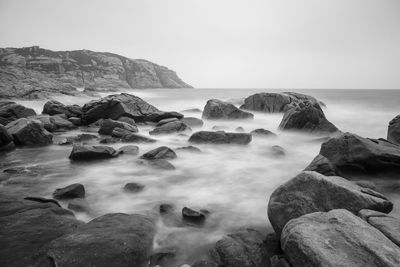 Rocks on sea shore against sky