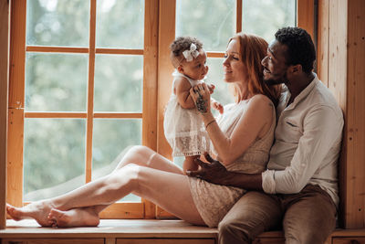 Friends sitting on window sill