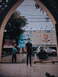 Rear view of people walking on street in city