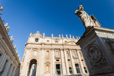 Low angle view of statue of historic building against sky