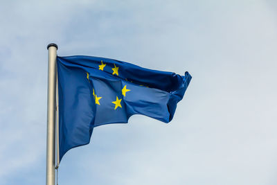 Low angle view of flag against blue sky