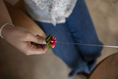 Close-up of woman holding flower in needle