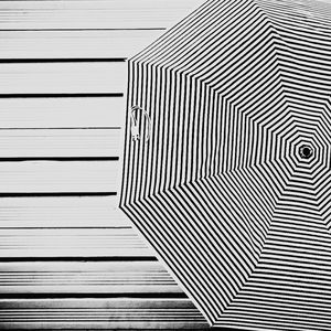 Directly above shot of striped umbrella on boardwalk