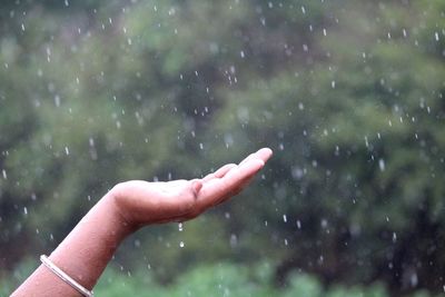 Person hand on wet glass during rainy season