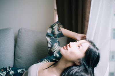 Young woman relaxing on sofa at home