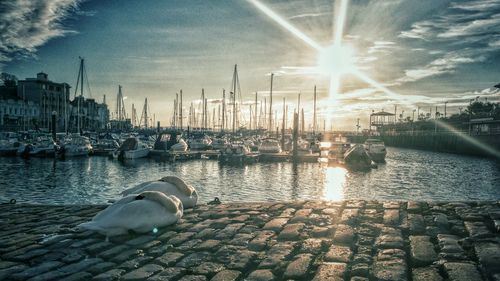 Boats in sea against sky during sunset