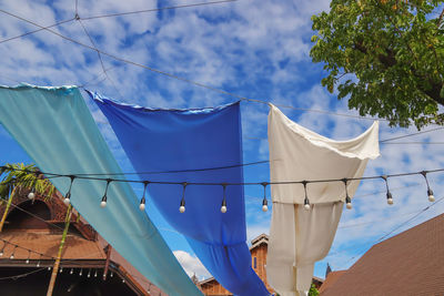 Low angle view of sunscreen and blue sky