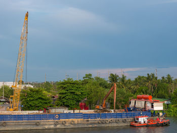 Cranes at construction site against sky