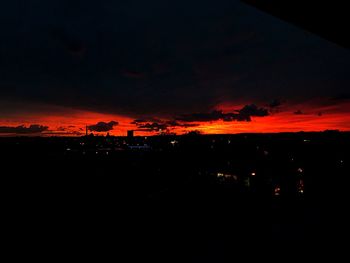 Silhouette landscape against dramatic sky at sunset