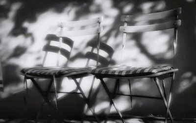 Close-up of chairs on table