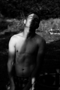 Portrait of shirtless man standing outdoors