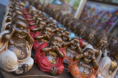 Dozen of small colored buddhas statues displayed on a stall at the ubud market, indonesia