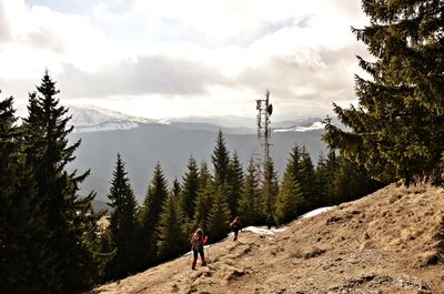 Man with arms raised on mountains against sky