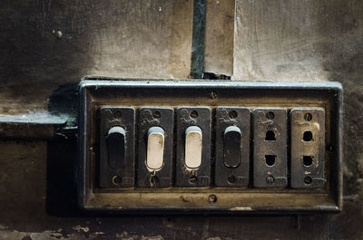 Close-up of old light switches on wall