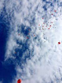 Low angle view of balloons flying against sky