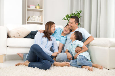 Happy family sitting on sofa at home