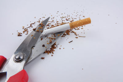 High angle view of cigarette on table against white background