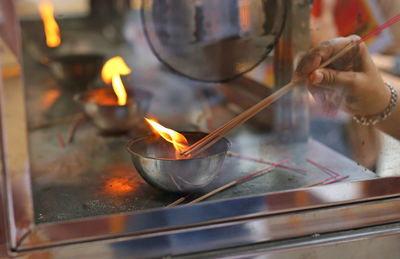 Person holding burning candles