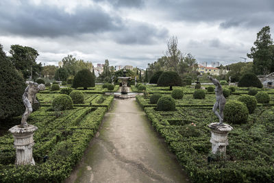 Park with decorative green bushes and maze on a cloudy day in lisbon, portugal