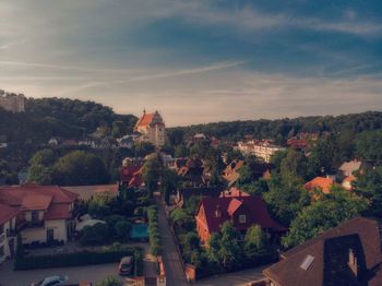 Houses and buildings in town against sky