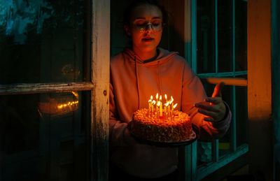 Young woman holding birthday cake