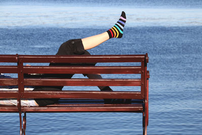 Woman relaxing on beach against sea