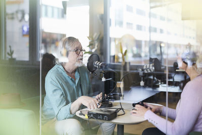 Male radio presenter talking with his guest on radio show or podcast