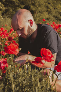 Woman with red flowers on field