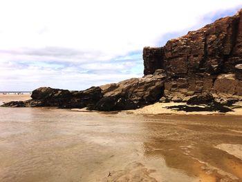 Rock formations by sea against sky