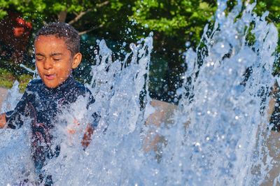 Full length of boy splashing water