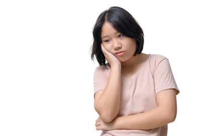 Portrait of young woman against white background