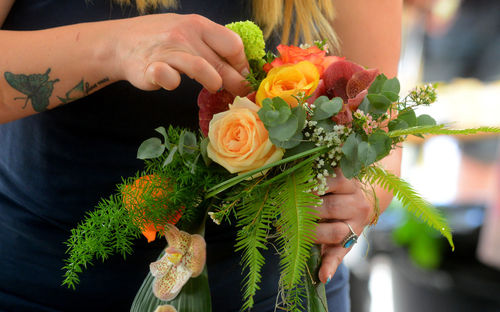 Midsection of woman holding rose bouquet