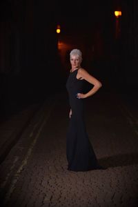 Portrait of woman standing on street at night